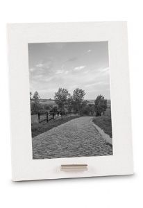 White photo frame with small tube for cremation ashes